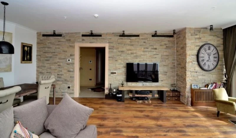 Taş kaplamayı TV ünitesi duvarı ile sınırlamayın. Kapı çerçevesi ve kolonları da kaplayarak yaşam alanınızda kesintisiz ve akıcı bir doku bütünlüğü oluşturun. bütüncül taş kaplama salon duvarı kolon kaplama kapı çerçevesi modern rustik